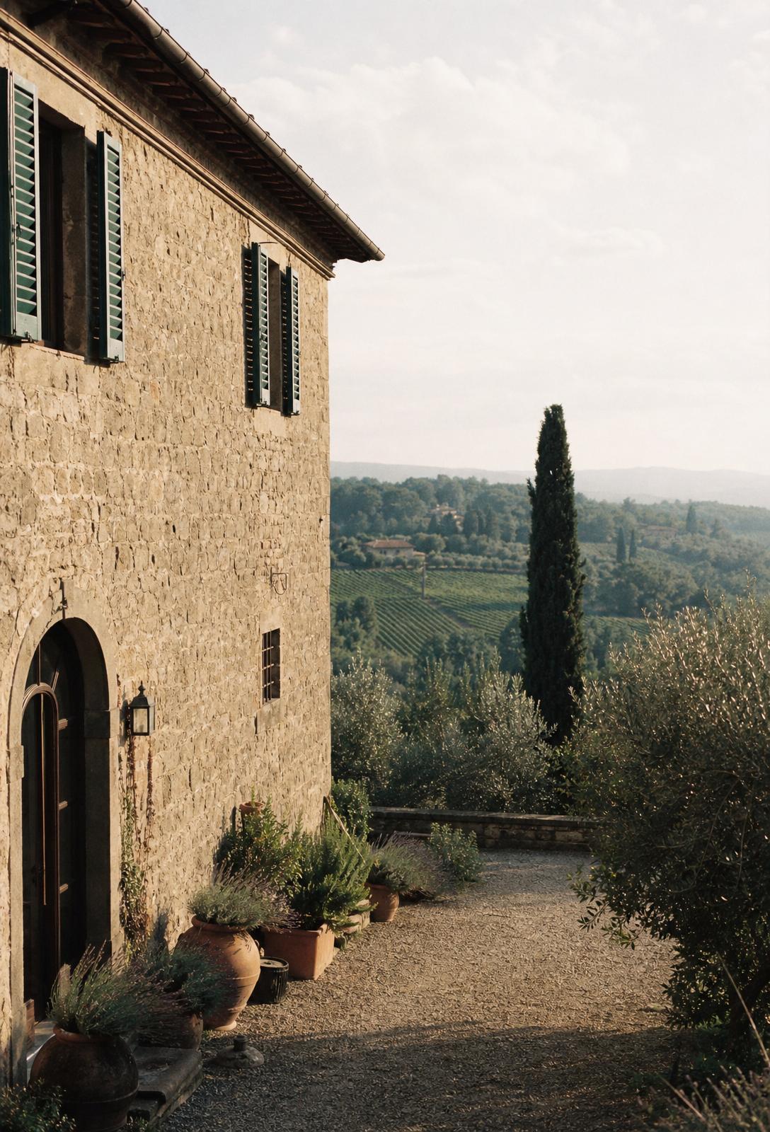 A rustic Tuscan villa with cypress trees and vineyard hills at golden hour
